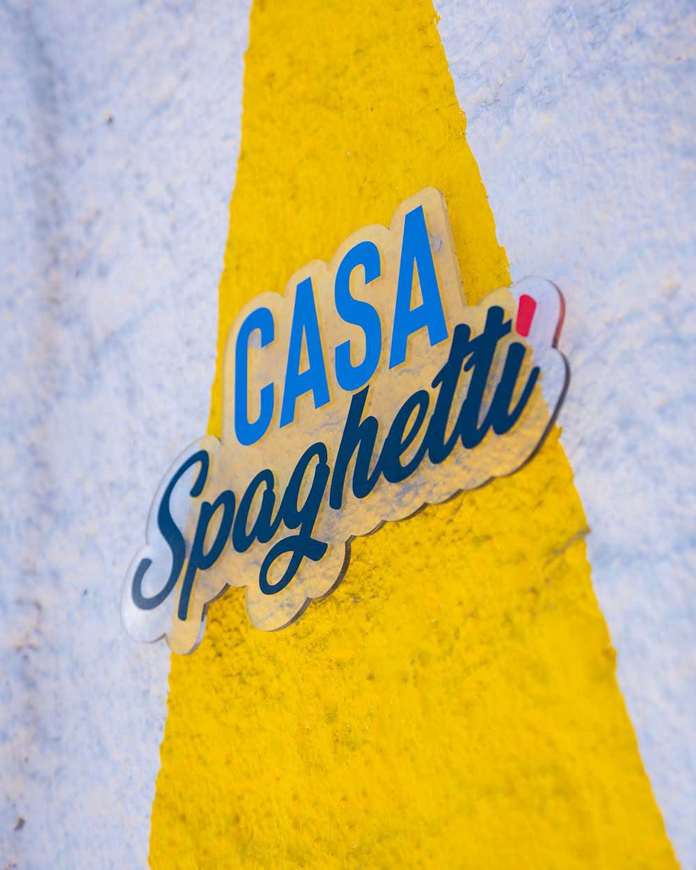 L'adesivo Casa Spaghetti sul muro giallo del locale di Tropea