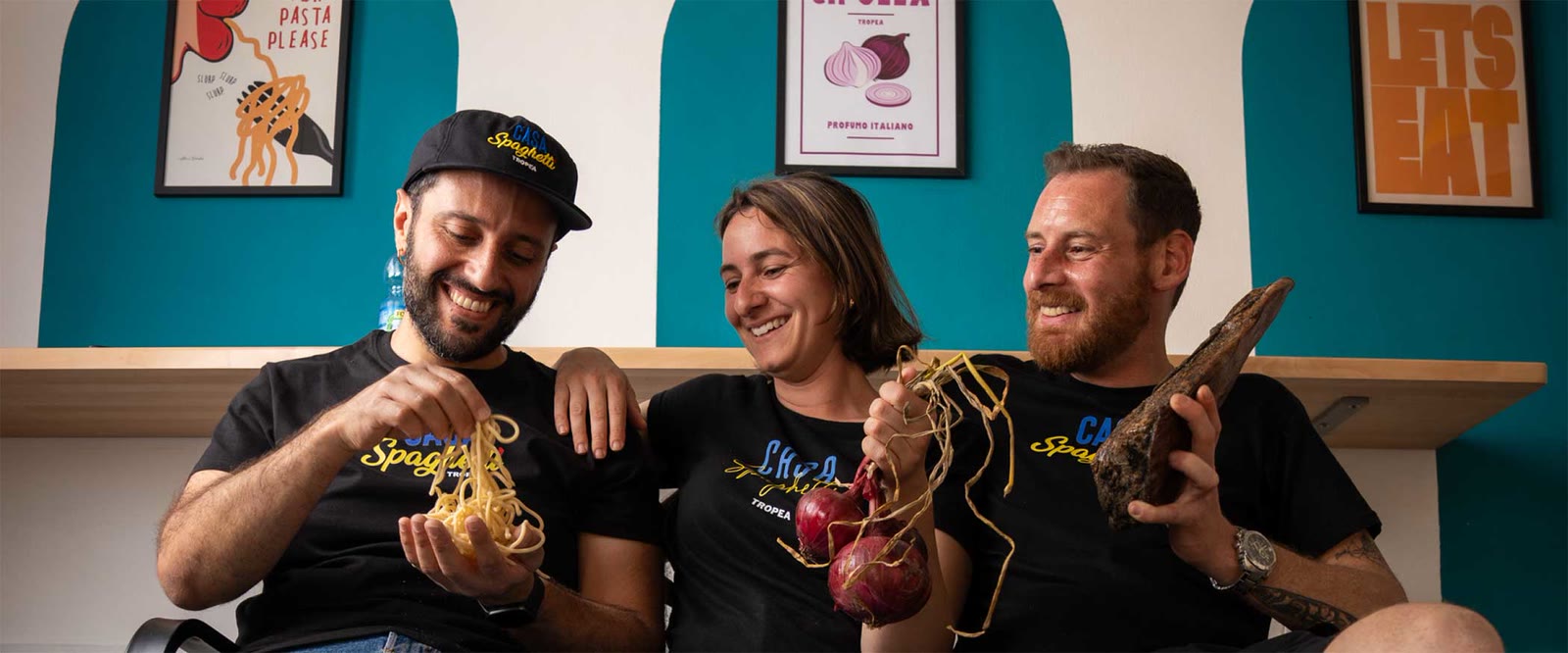 La crew di Casa Spaghetti nel locale, con gli spaghetti in mano e le cipolle rosse di Tropea